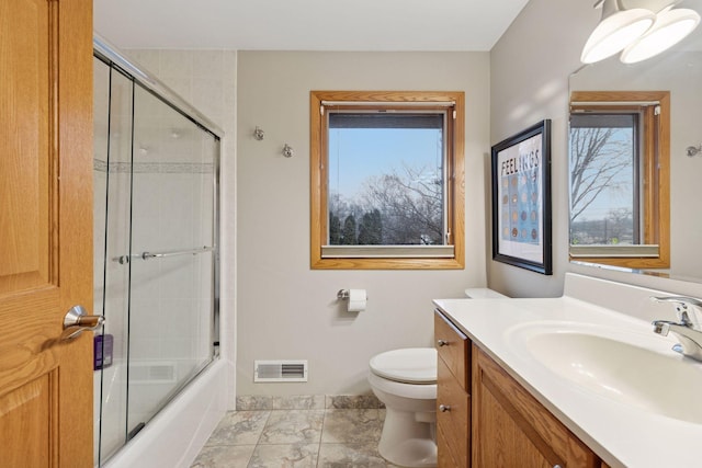 bathroom featuring shower / bath combination with glass door, visible vents, toilet, and vanity