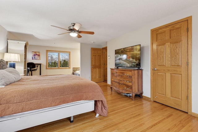 bedroom featuring light wood-type flooring, baseboards, and a ceiling fan