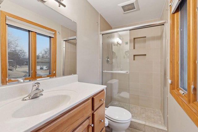 full bath with visible vents, a stall shower, toilet, and vanity