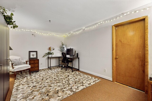 carpeted office featuring baseboards