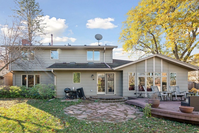 back of property featuring a wooden deck and a yard