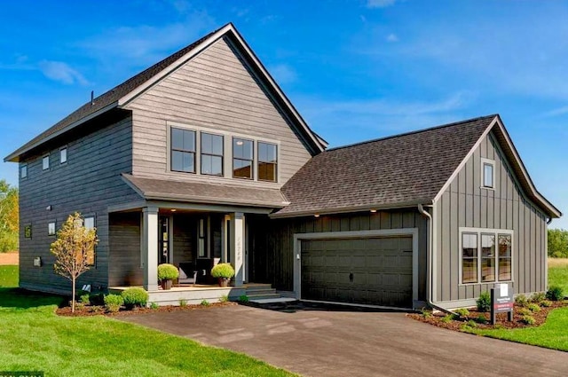 view of front facade featuring a front lawn, a garage, and a porch