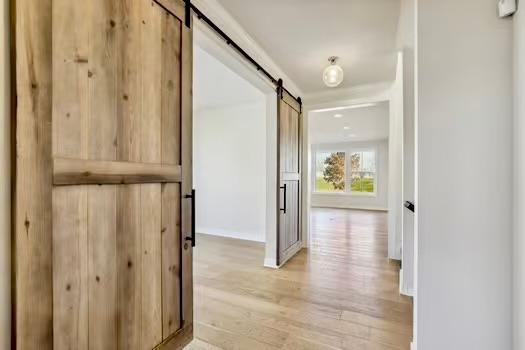 corridor featuring light hardwood / wood-style flooring and a barn door