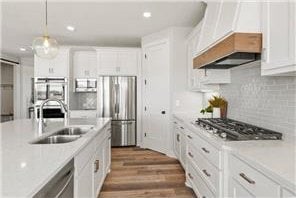 kitchen with stainless steel appliances, white cabinetry, pendant lighting, sink, and dark wood-type flooring