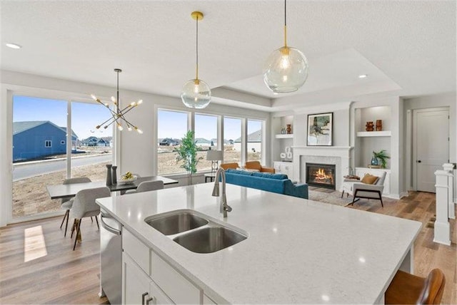 kitchen with white cabinetry, a wealth of natural light, and decorative light fixtures