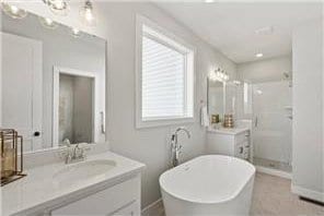 bathroom featuring shower with separate bathtub and vanity