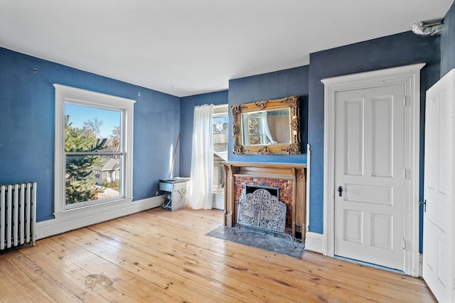 unfurnished living room featuring hardwood / wood-style flooring and radiator