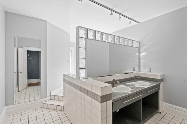 bathroom with tile patterned flooring, vanity, and rail lighting