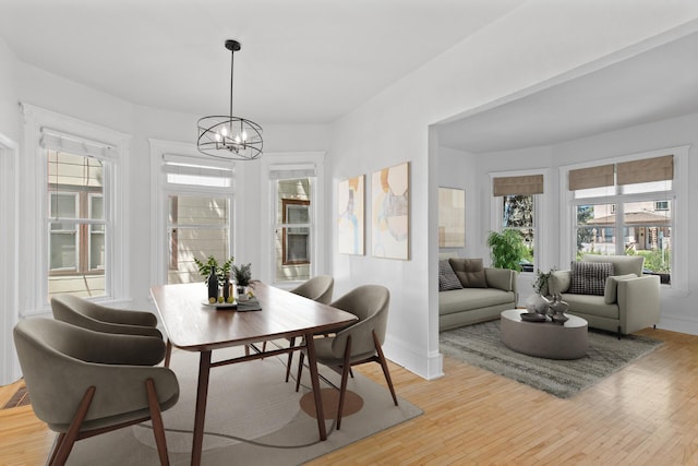 dining space featuring light hardwood / wood-style floors and an inviting chandelier