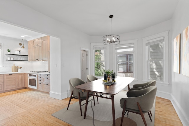 dining area featuring an inviting chandelier and light hardwood / wood-style floors