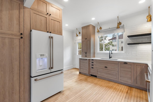 kitchen with light hardwood / wood-style floors, sink, backsplash, high end white refrigerator, and crown molding