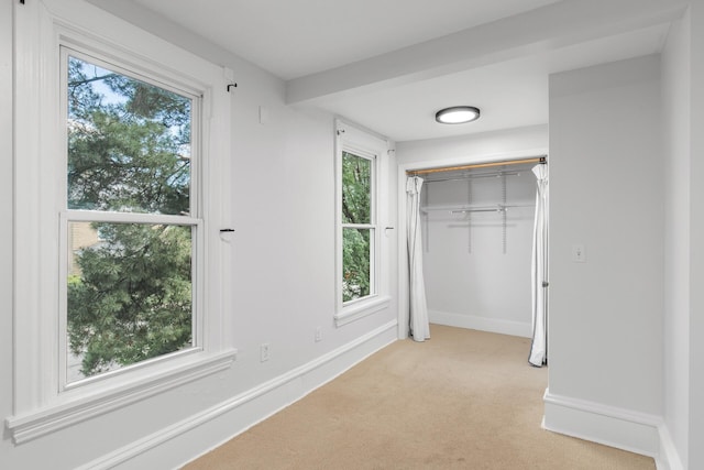 unfurnished bedroom with a closet and light colored carpet