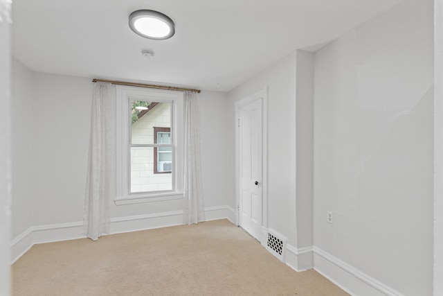 unfurnished room featuring light colored carpet