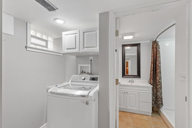 laundry area with washer / clothes dryer, cabinets, sink, and light tile patterned floors