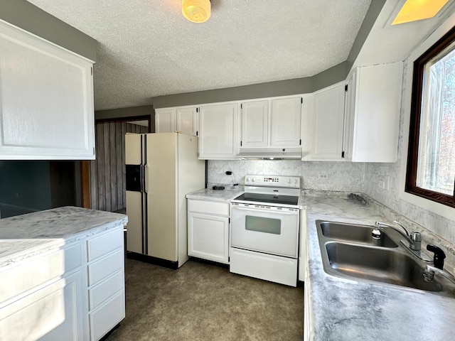 kitchen featuring dark carpet, a textured ceiling, sink, white cabinets, and white appliances