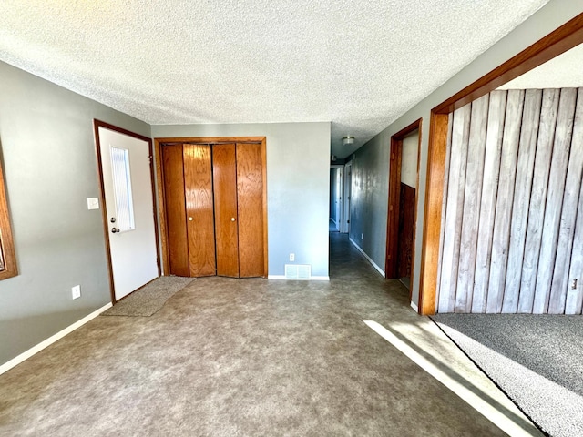 unfurnished bedroom featuring carpet flooring, a textured ceiling, and a closet