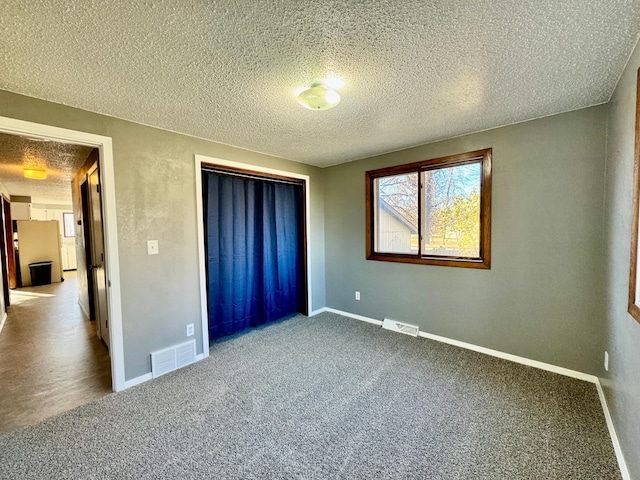 unfurnished bedroom with carpet flooring and a textured ceiling