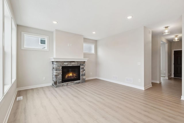 unfurnished living room featuring a fireplace and light hardwood / wood-style flooring