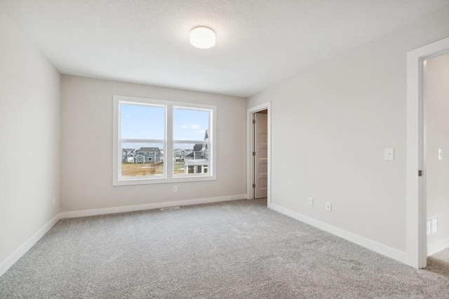 empty room with a textured ceiling and carpet