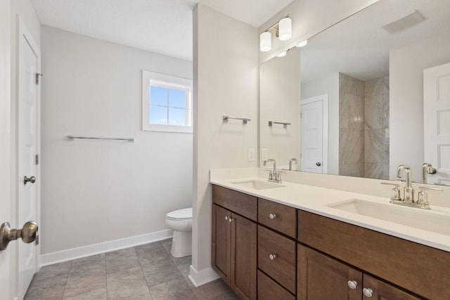 bathroom featuring tile patterned floors, vanity, toilet, and a shower