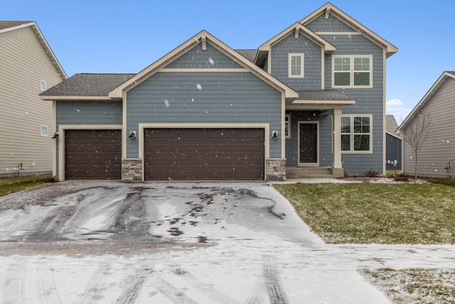 craftsman inspired home featuring a garage and a yard