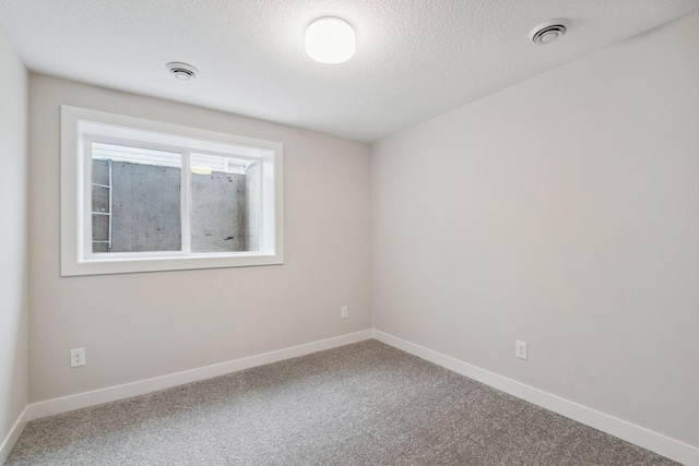 carpeted spare room featuring a textured ceiling