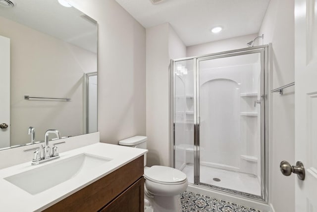 bathroom with vanity, a shower with shower door, and toilet