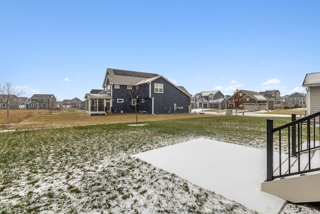 view of yard featuring a sunroom and a residential view