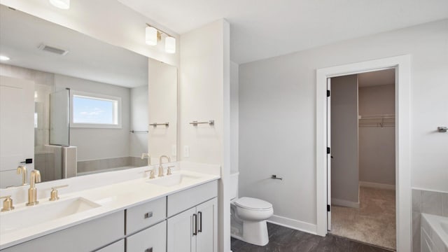 full bathroom featuring toilet, vanity, and separate shower and tub