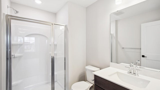 bathroom featuring toilet, a shower with door, and vanity