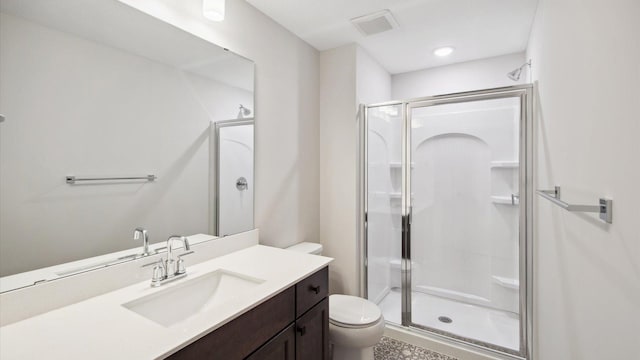 bathroom with an enclosed shower, vanity, and toilet