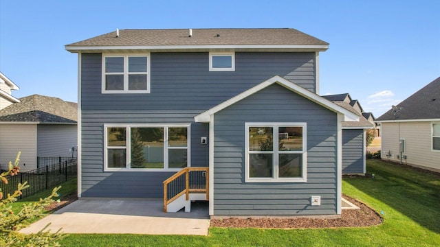 back of house with a patio area and a lawn