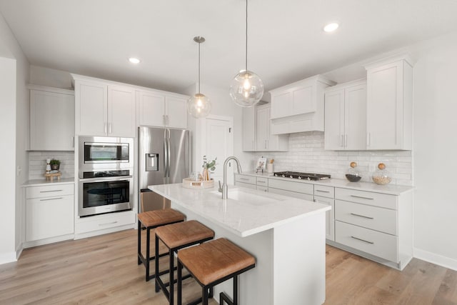 10238 Arrowwood Path, Woodbury, MN 55129 - kitchen featuring stainless steel appliances, a sink, a breakfast bar, decorative backsplash, and light wood finished floors