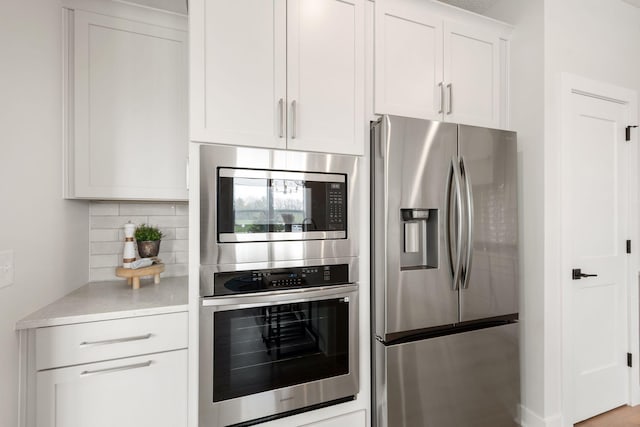 10238 Arrowwood Path, Woodbury, MN 55129 - kitchen with appliances with stainless steel finishes, decorative backsplash, and white cabinetry