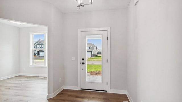 10238 Arrowwood Path, Woodbury, MN 55129 - entryway featuring wood finished floors, baseboards, and a chandelier