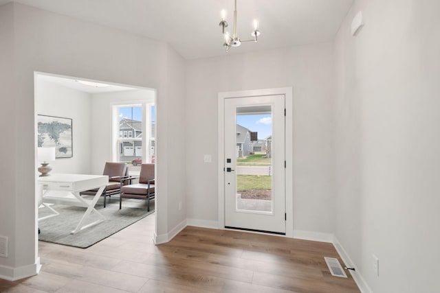 10238 Arrowwood Path, Woodbury, MN 55129 - doorway to outside with wood finished floors, a chandelier, and baseboards