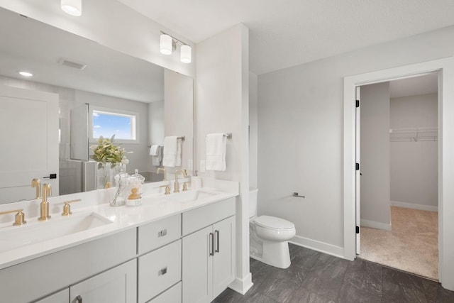 10238 Arrowwood Path, Woodbury, MN 55129 - bathroom featuring toilet, double vanity, a spacious closet, baseboards, and a shower