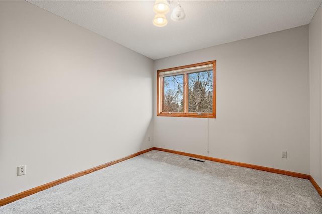 carpeted spare room with a textured ceiling