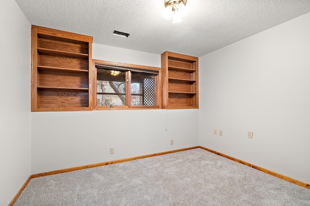 spare room with carpet floors and a textured ceiling