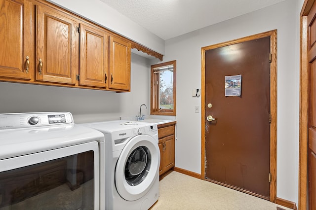 clothes washing area featuring a textured ceiling, cabinets, independent washer and dryer, and sink