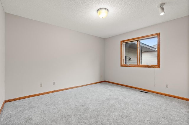 carpeted spare room featuring a textured ceiling