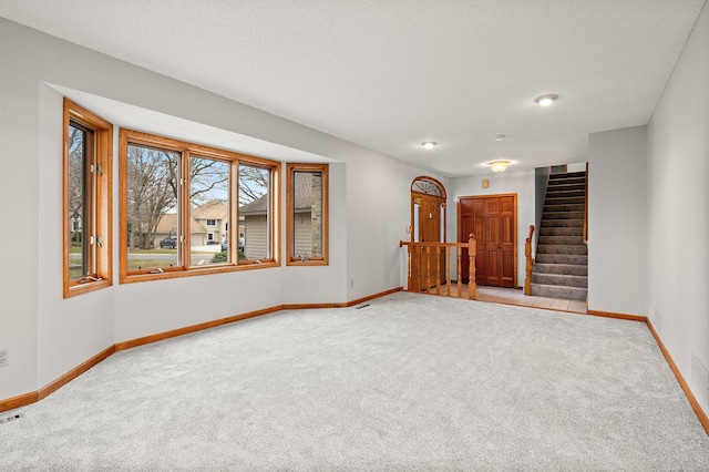 carpeted empty room with a textured ceiling