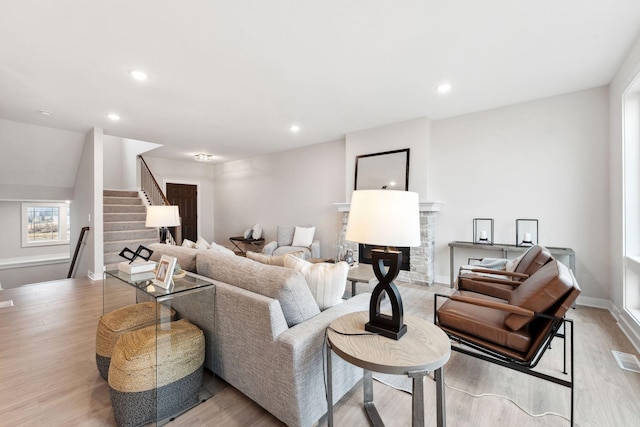11728 35th St N, Lake Elmo, MN 55042 - living room featuring stairs, light wood-type flooring, a stone fireplace, recessed lighting, and baseboards