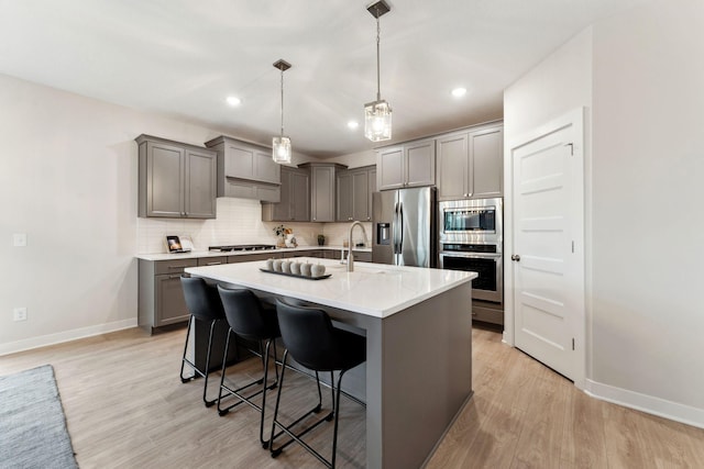 11728 35th St N, Lake Elmo, MN 55042 - kitchen with appliances with stainless steel finishes, baseboards, backsplash, a breakfast bar, and light wood finished floors