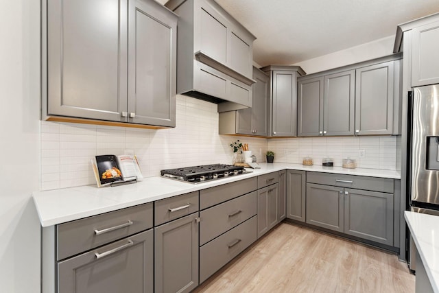 11728 35th St N, Lake Elmo, MN 55042 - kitchen with gray cabinetry, stainless steel appliances, light wood-style floors, and tasteful backsplash