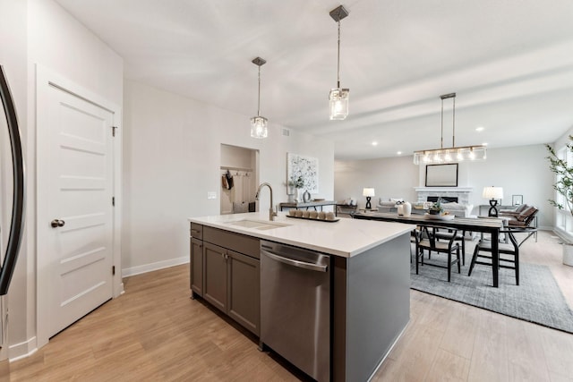 11728 35th St N, Lake Elmo, MN 55042 - kitchen with stainless steel dishwasher, a sink, open floor plan, light wood-style floors, and baseboards