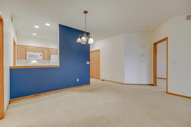 carpeted spare room with a notable chandelier