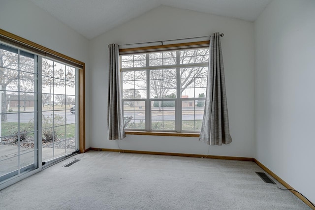 carpeted empty room with lofted ceiling