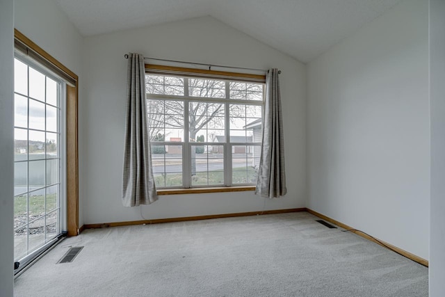 carpeted empty room with lofted ceiling and a healthy amount of sunlight