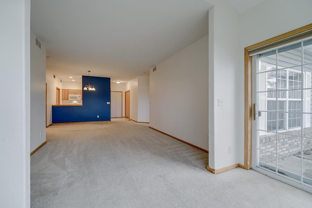 unfurnished living room with an inviting chandelier and carpet flooring